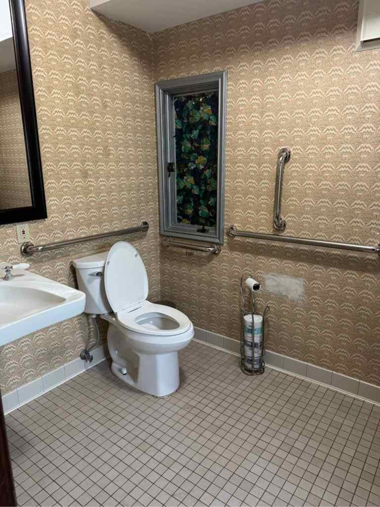 Wheelchair accessible women's bathroom by the restaurant and lounge area with grab bars on the left side