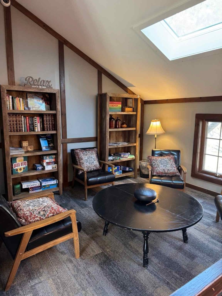a cozy space with bookshelves full of games and chairs around a table