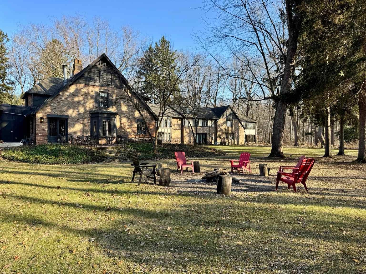 outside view of the hotel with a circle of chairs around a fire pit