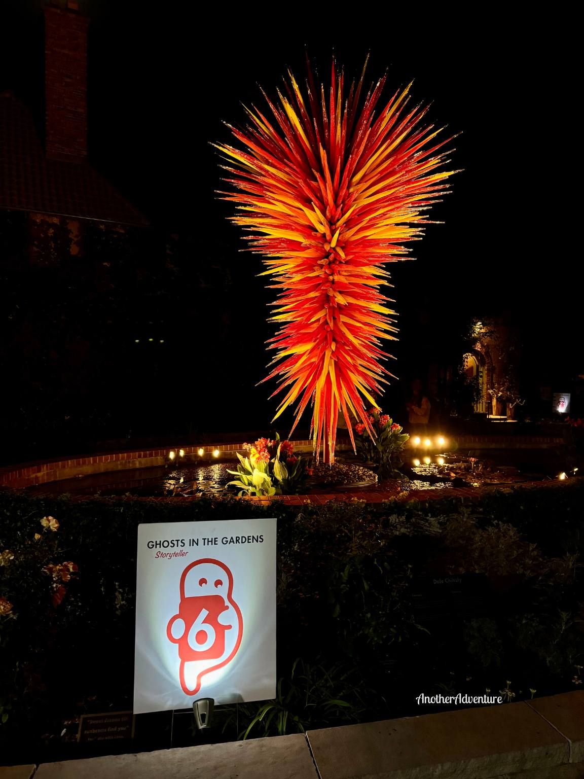 ghosts in the gardens sign and orange sculpture art piece