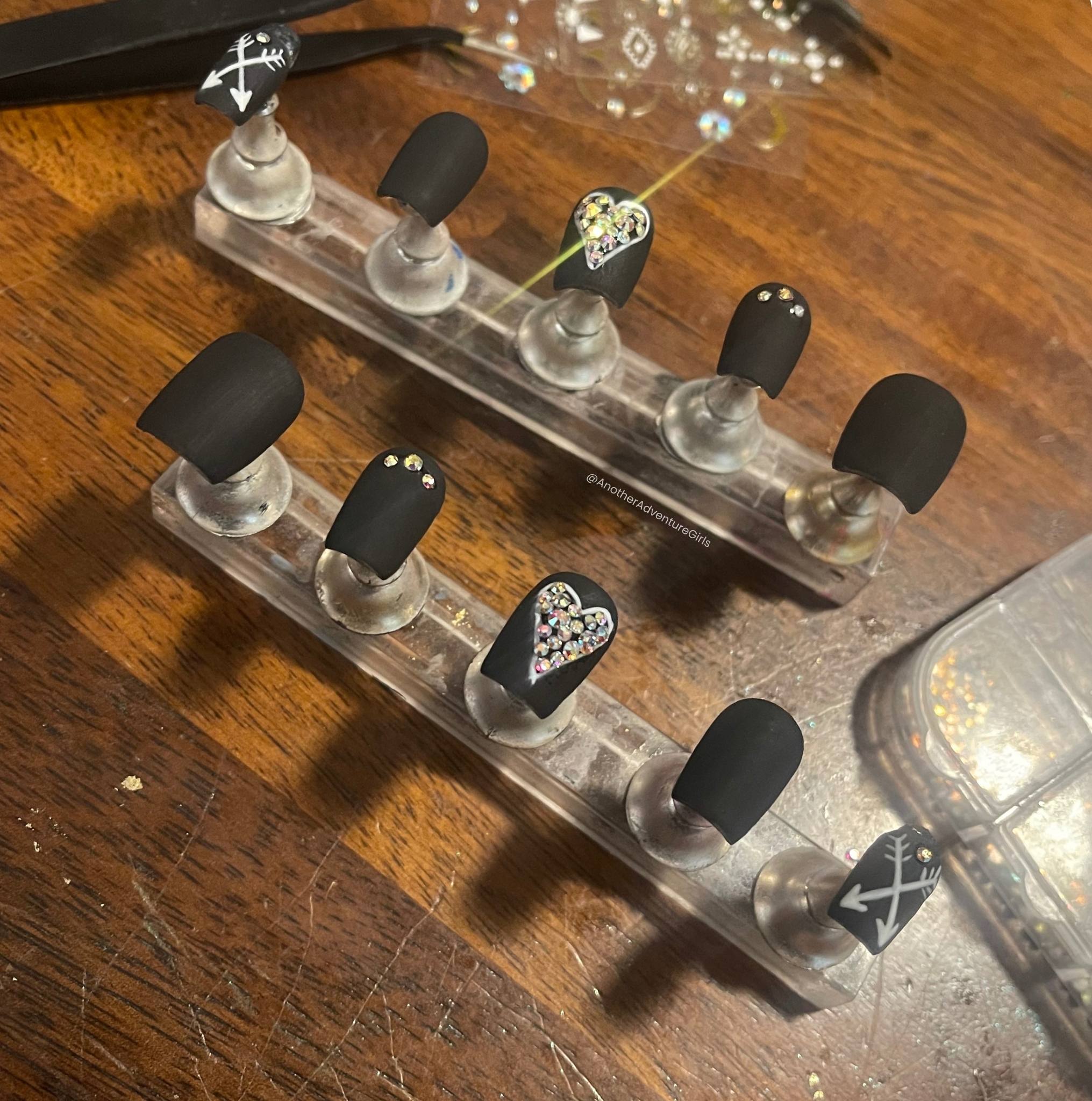 matte black press on nails with silver gemstone details shown on nail stand displays