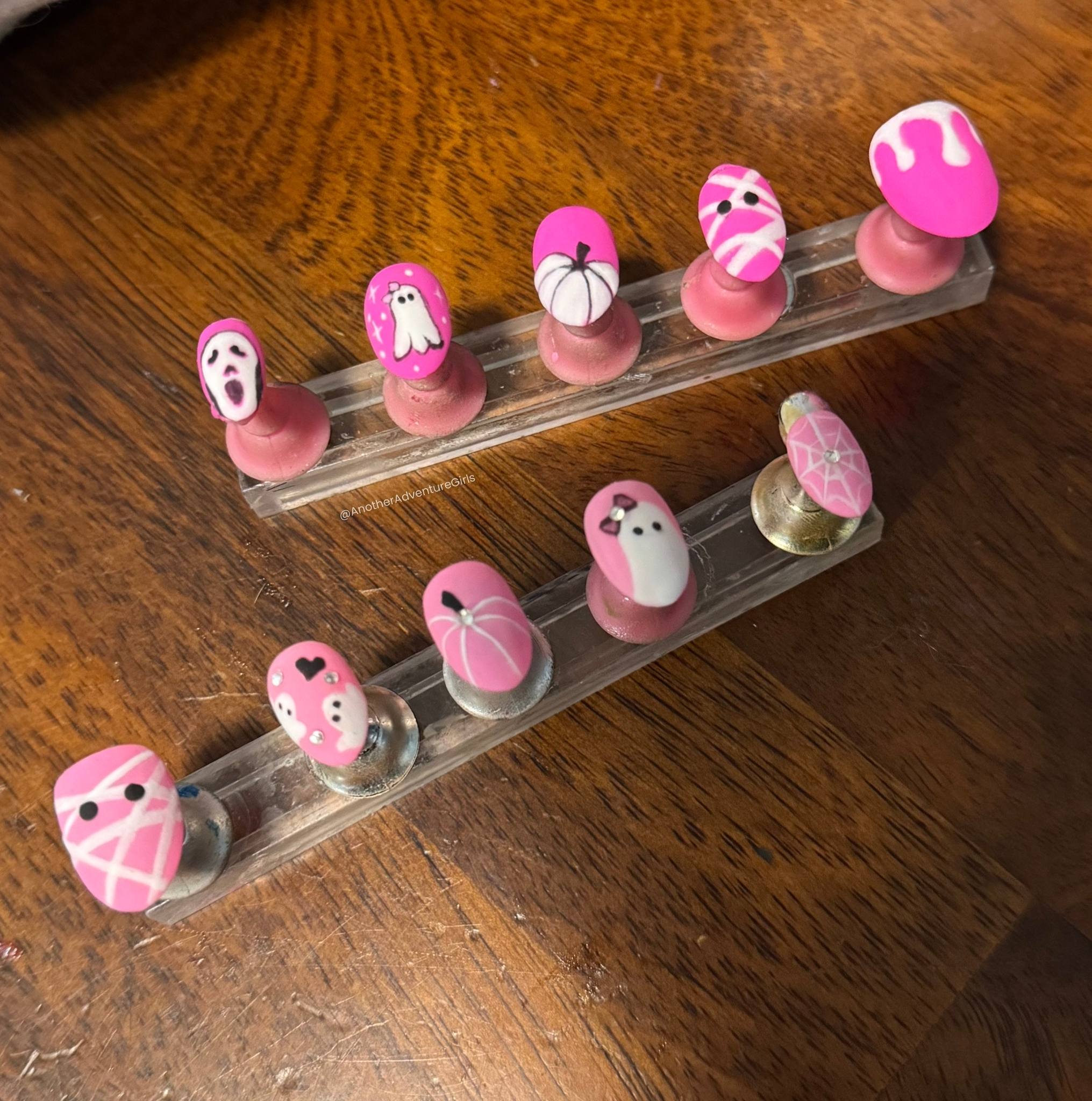 a set of hot pink and light pink halloween press on nails, both with white and a touch of black in the design 