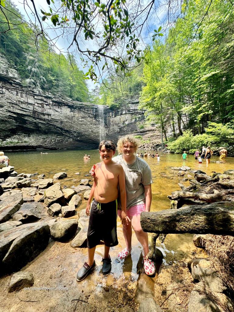 two boys standing in the water in front of Foster Falls