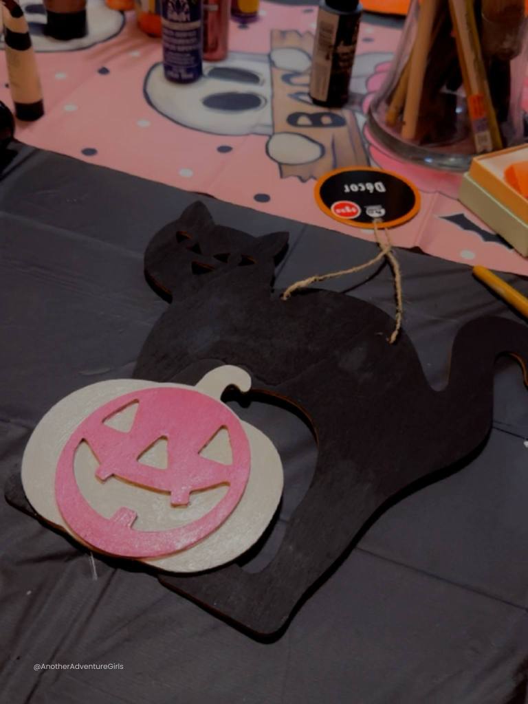 wooden figure of a cat and pumpkin painted black and pink