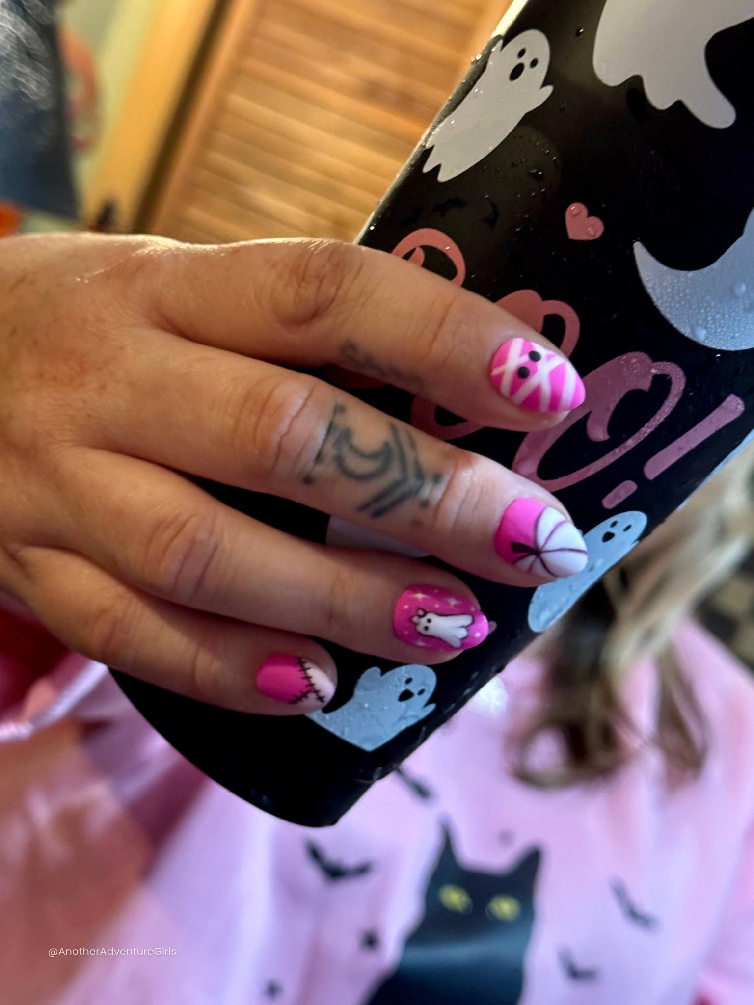 hot pink halloween press on nails shown being worn on a hand