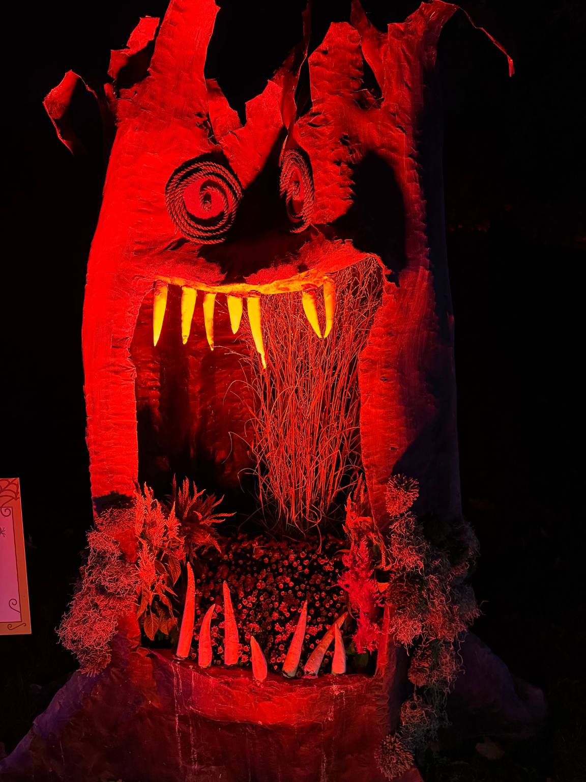 red monster with an open mouth and teeth glowing