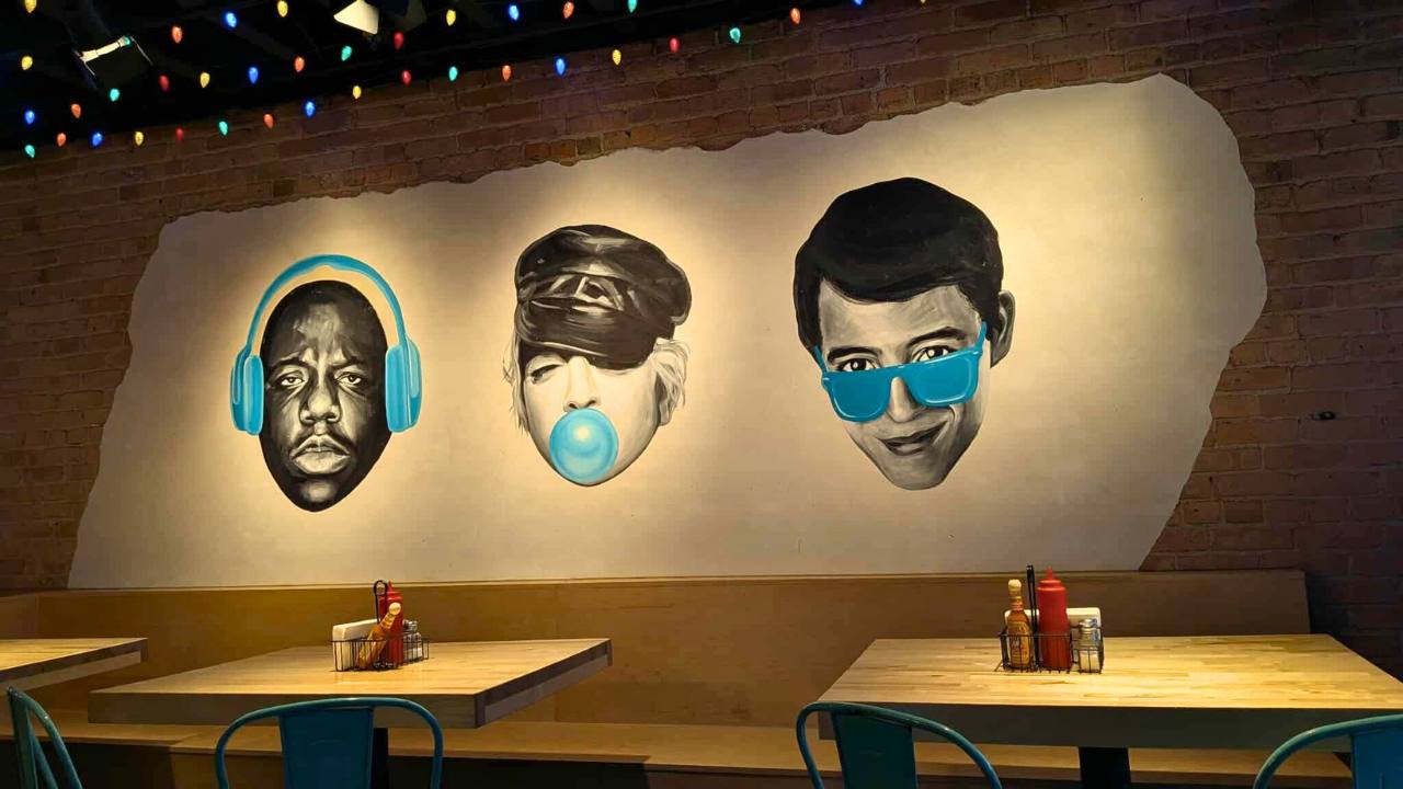  black and white mural of heads - biggie smalls, Madonna and Ferris Bueller each with a turquoise accent