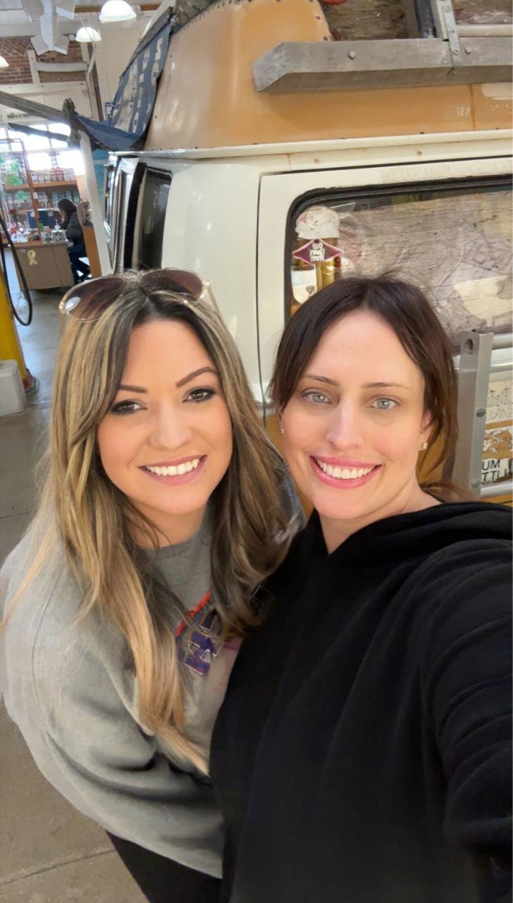 Jodi (left) and Erin (right) smiling in front of Bob Waldmire's iconic VW bus inside the Route 66 museum