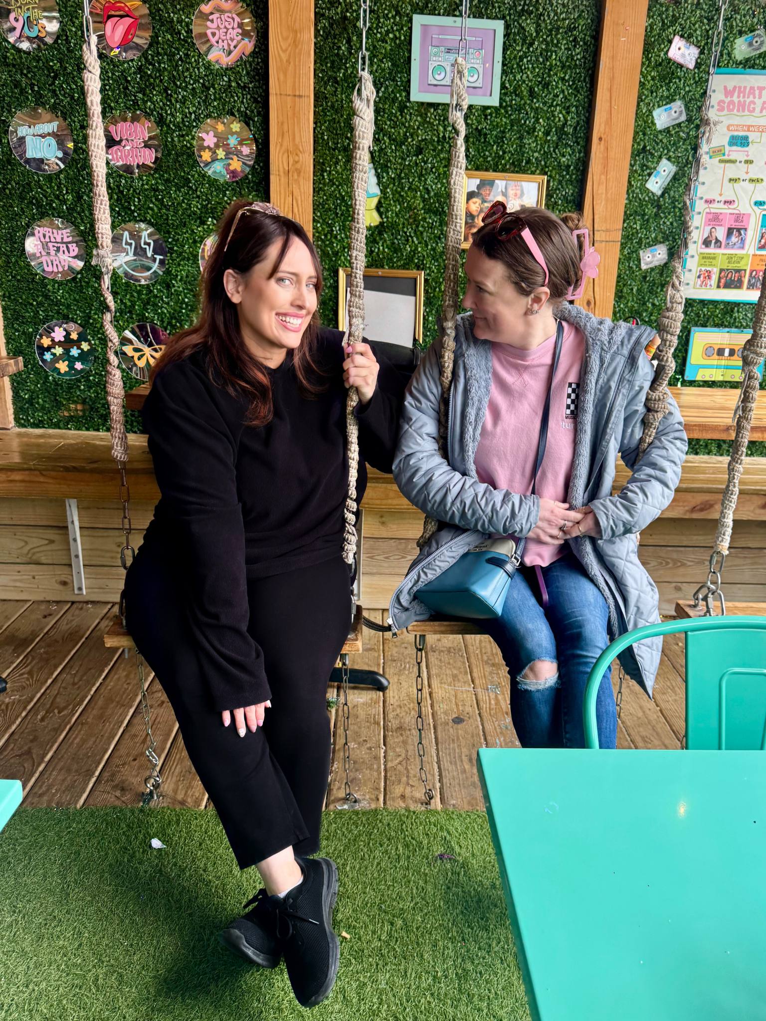 erin and tiffany talking and laughing on wooden swings