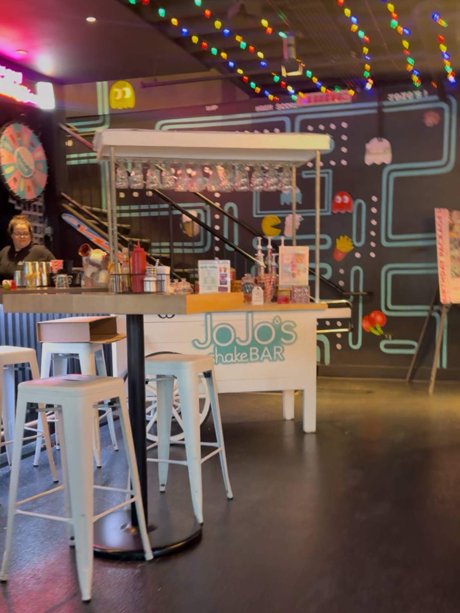 white ice cream cart in front of a pac-man painted wall