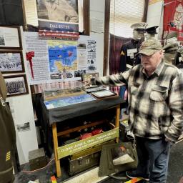 Dave Estes pointing to an information board at the World War II museum