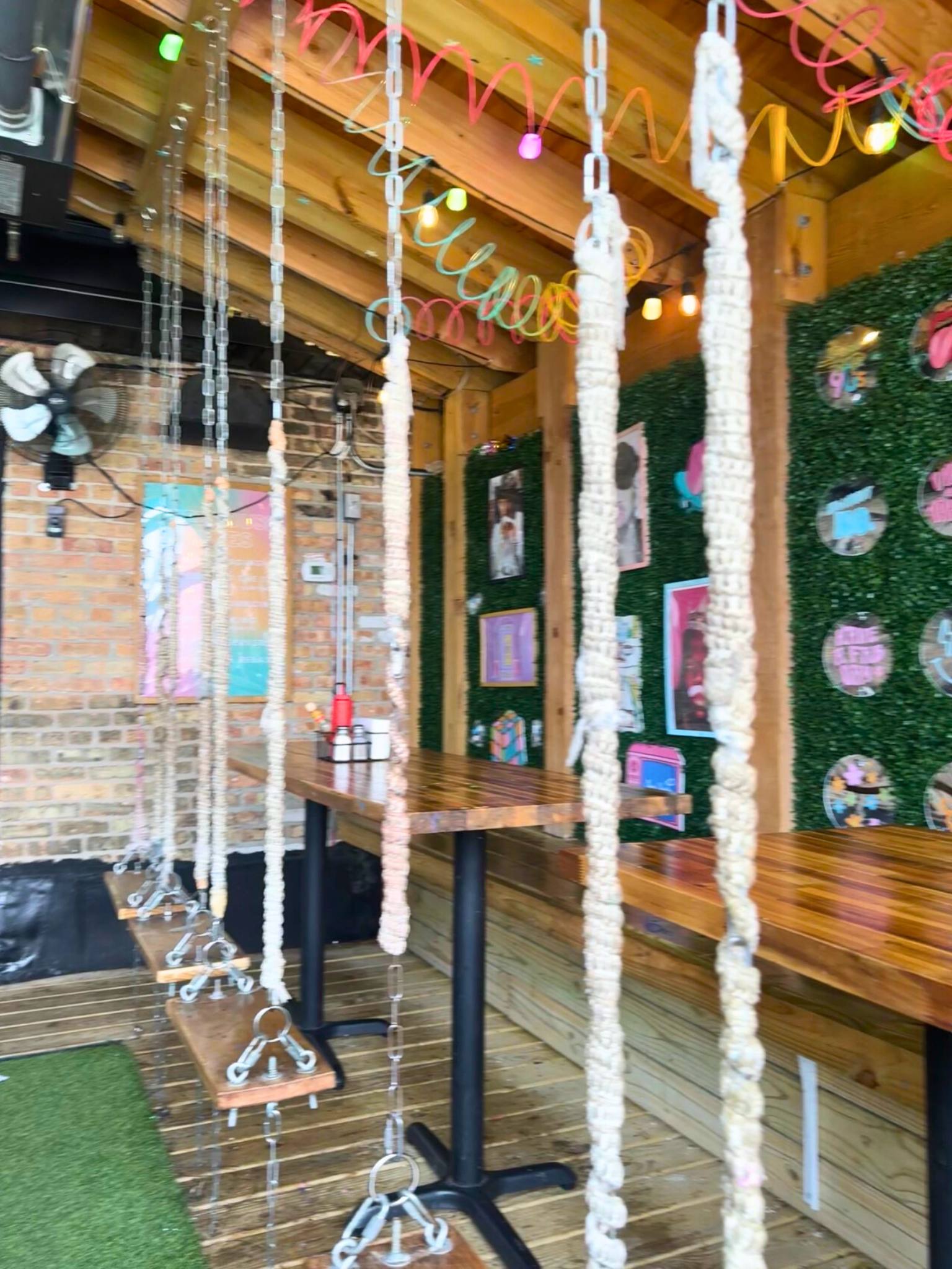 wooden swings in front of a green wall