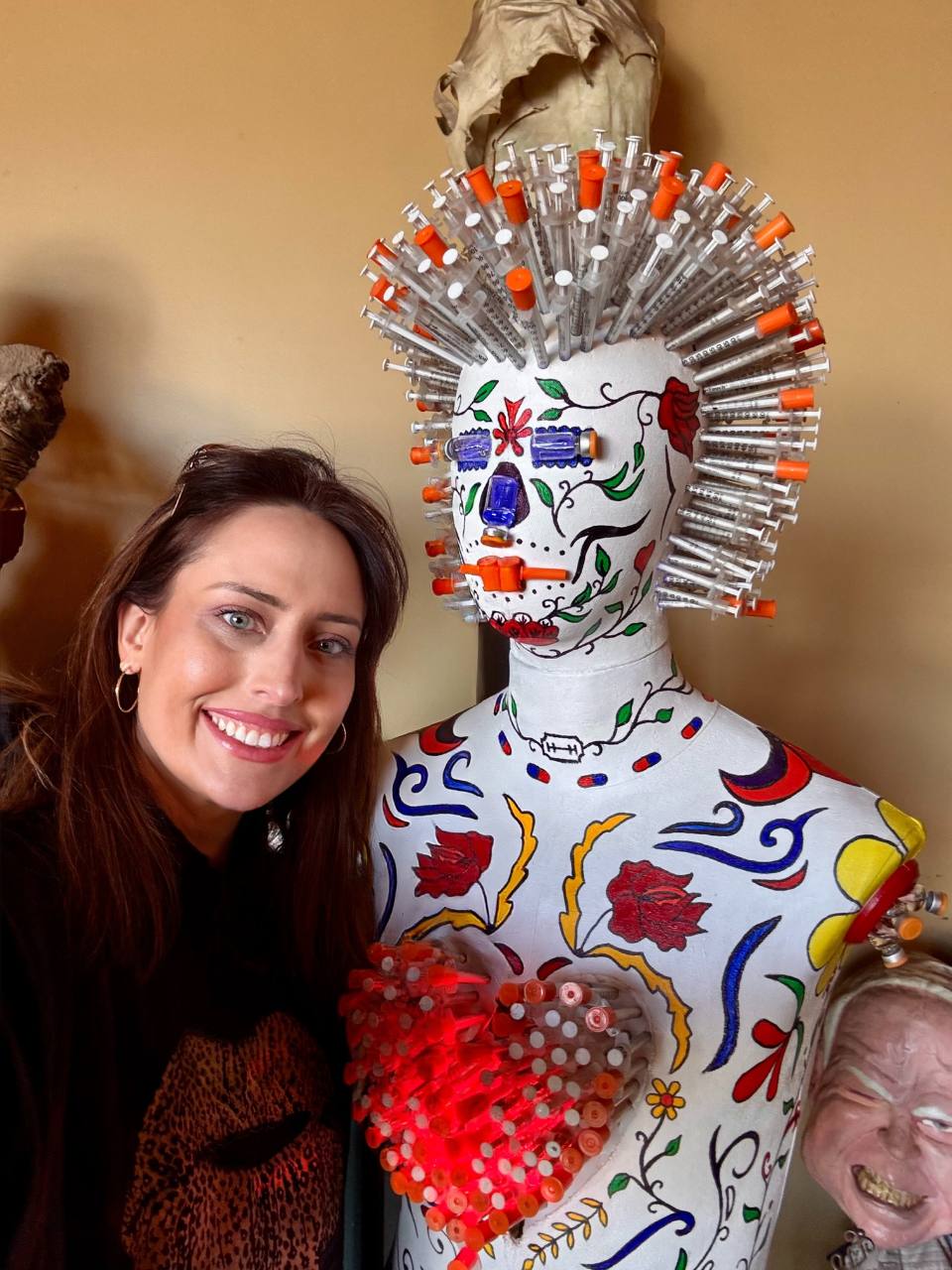 erin smiling next to an art mannequin with needles in its head for hair