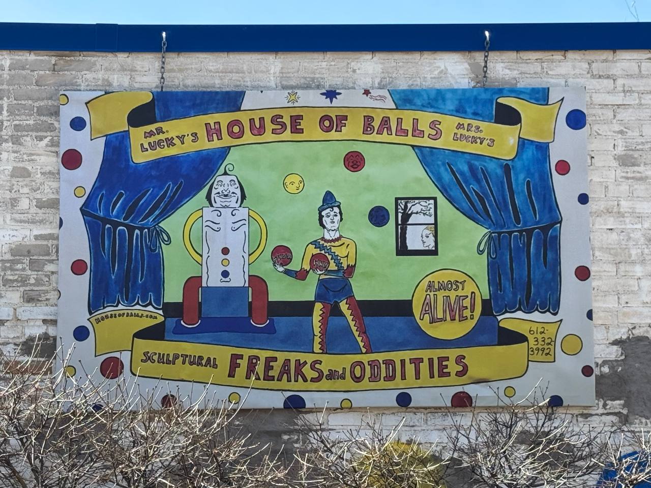 painting on the side of the building with clowns, balls and the words "house of balls"