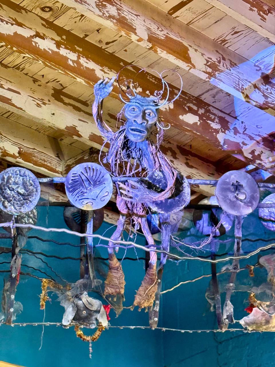 a metal goblin sculpture hanging 