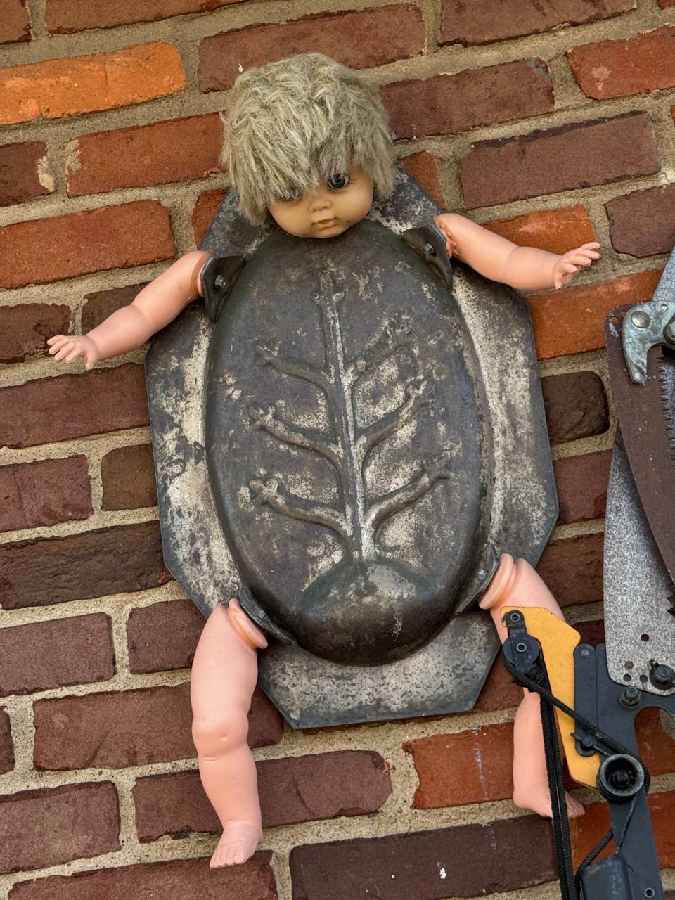 art sculpture featuring metal and doll parts
